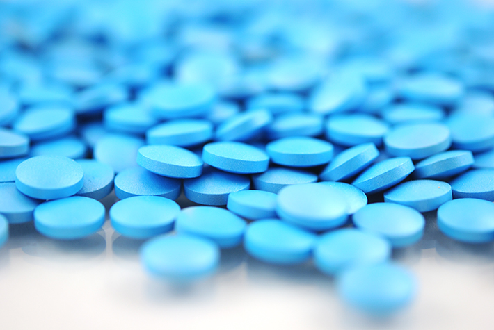 Bright blue round  tablets with natural shadow isolated on white background